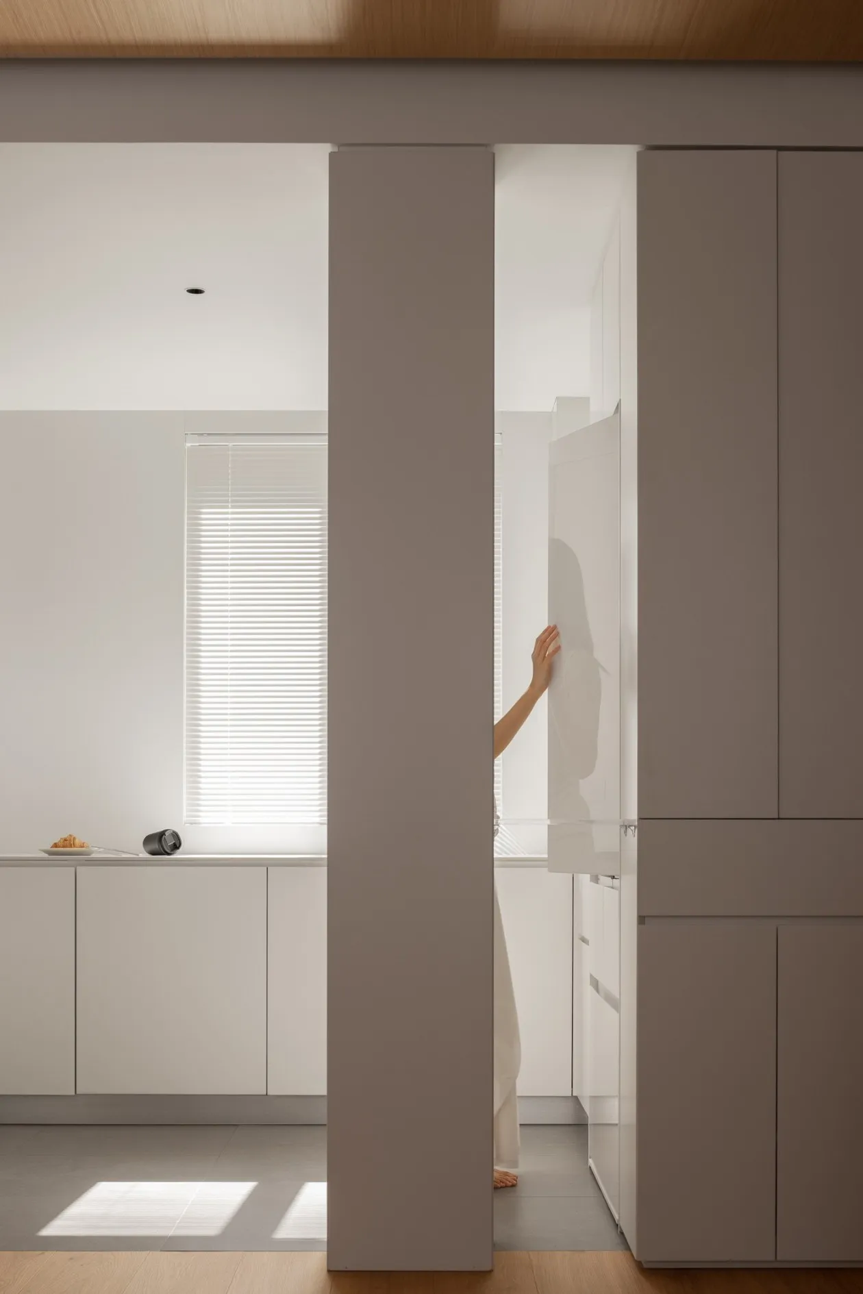 A modern minimalist kitchen features white cabinets and a clean, uncluttered design, showcasing sleek and stylish aesthetics