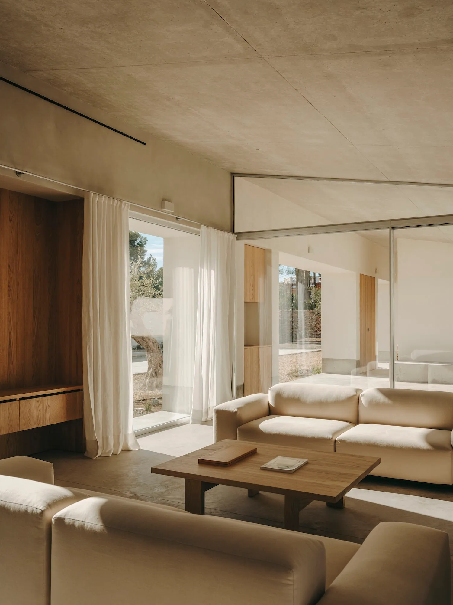 Modern minimalistic living room featuring light wood and concrete elements