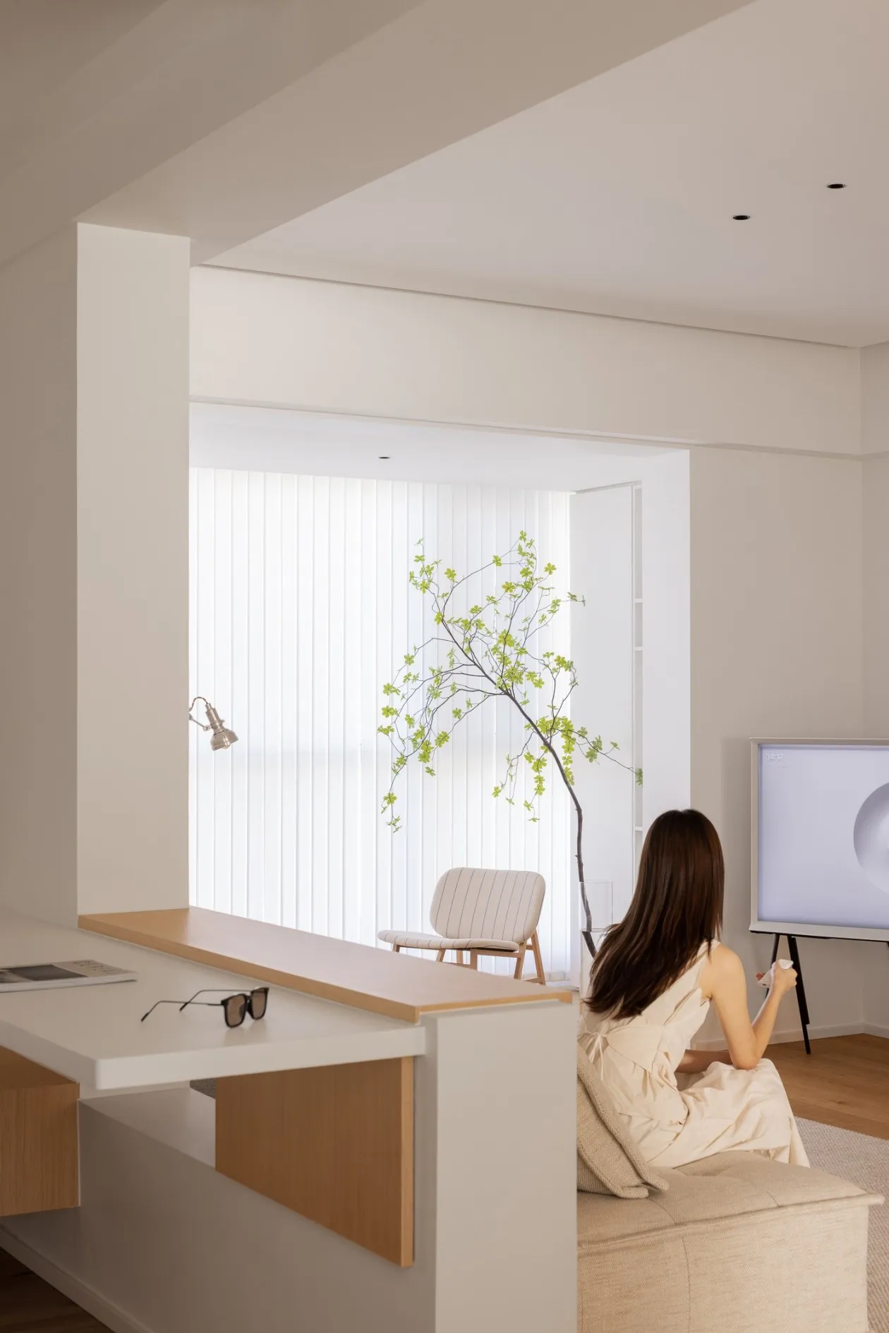 A modern living room with neutral-toned furniture and decor, featuring a minimalistic design and natural light.