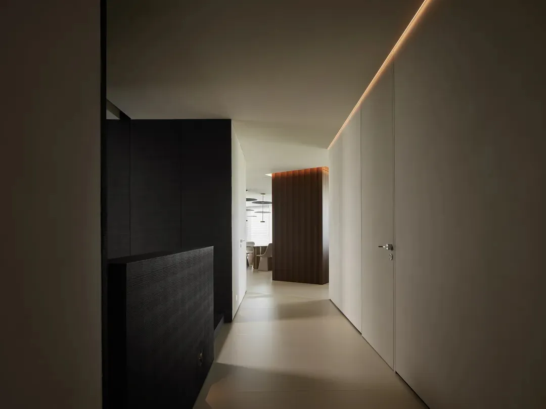 A minimalist modern corridor with white walls and hidden lighting.
