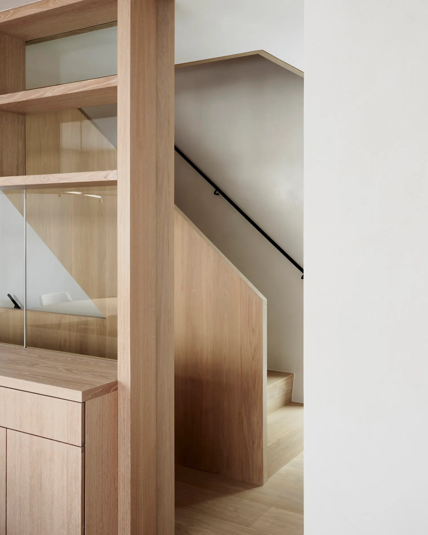 Modern wooden staircase within a minimalist interior design setting.