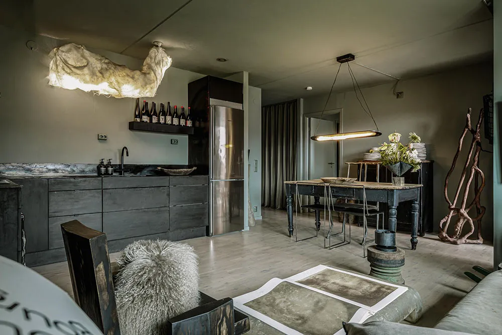 An industrial-style living room with metal furniture, concrete flooring, and wooden accents.