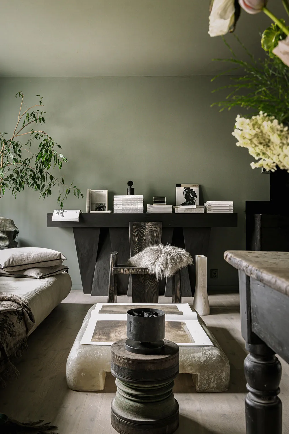 A modern industrial living room featuring rustic wooden furniture, stone accents, and metal elements.
