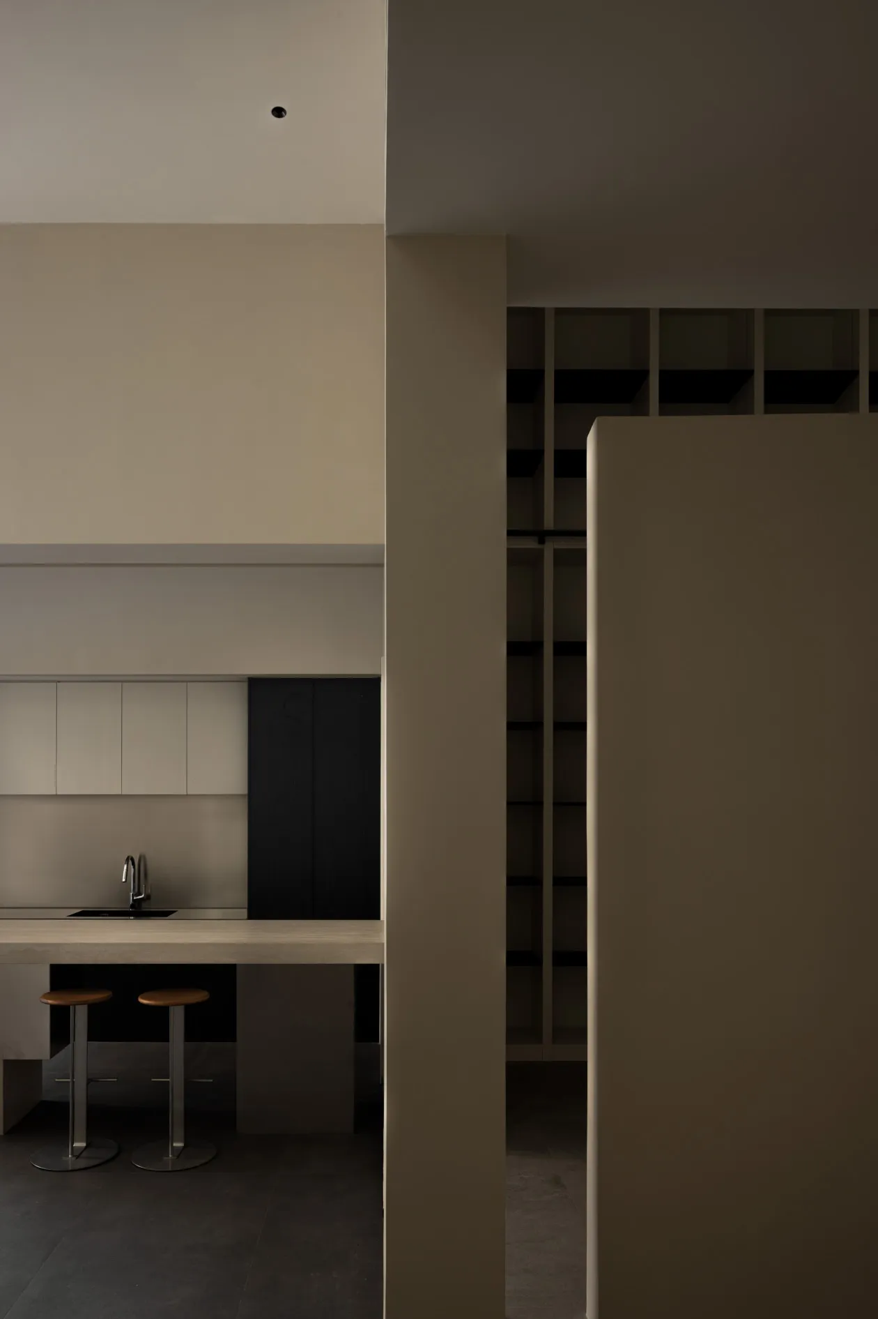 A minimalist kitchen with concrete countertops and minimalist cabinets.