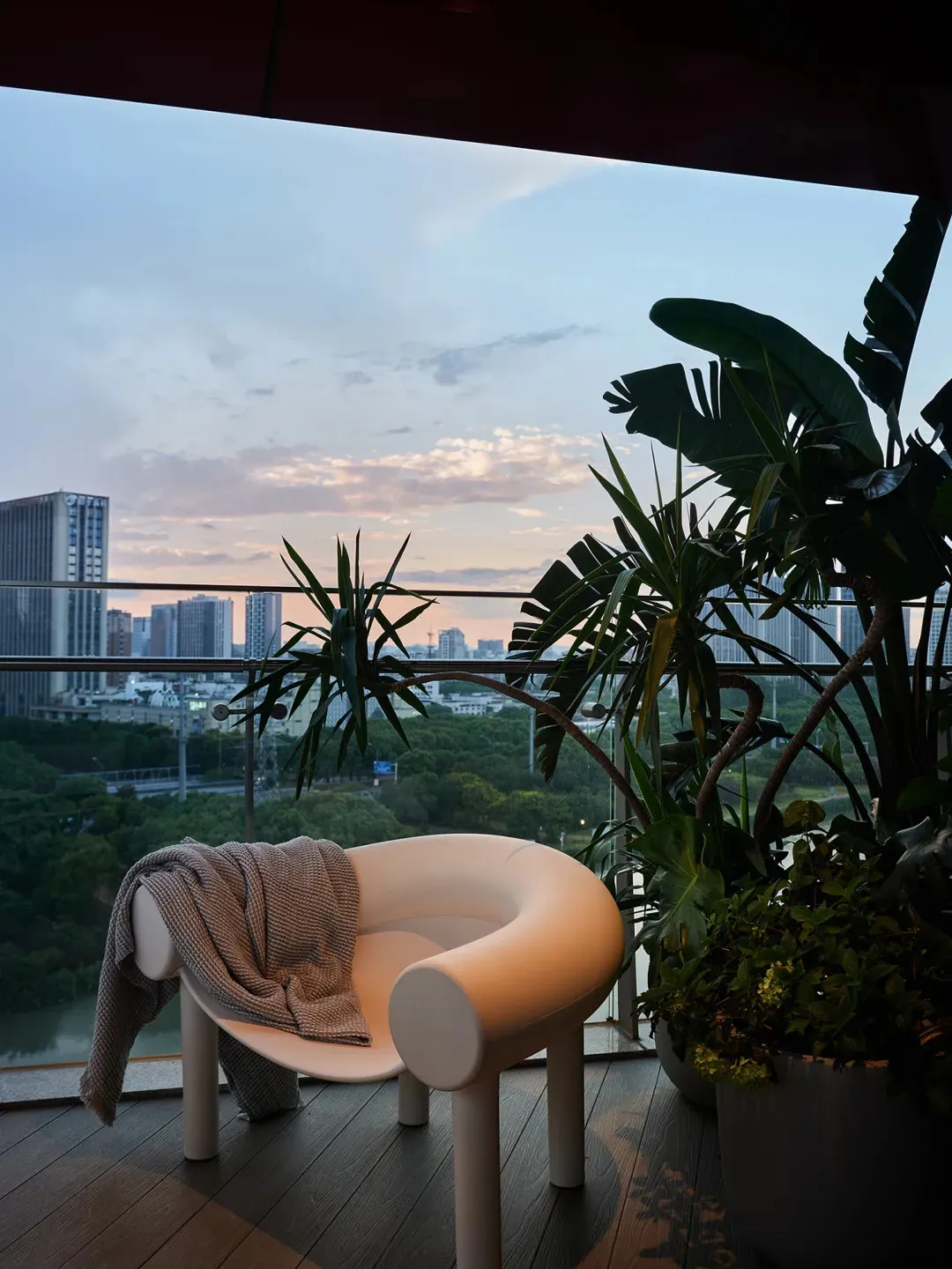 現代陽台擁有城市景觀,搭配盆栽植物與木質平台。