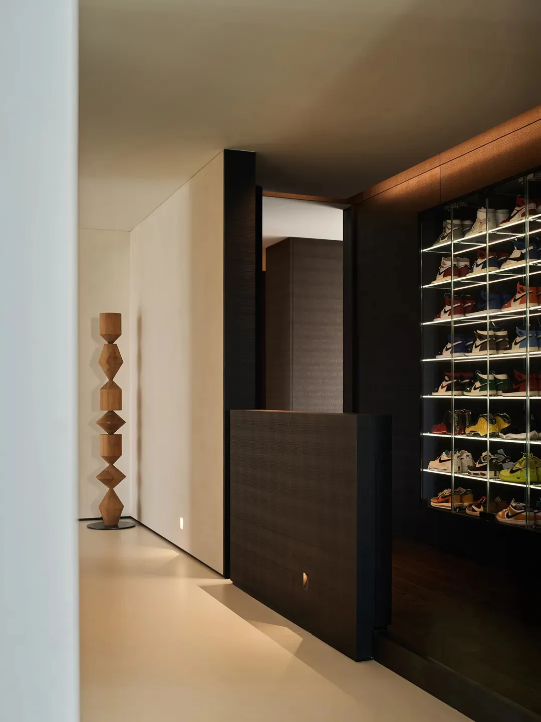 A modern interior featuring a shoe closet with a minimalistic design and wooden materials.