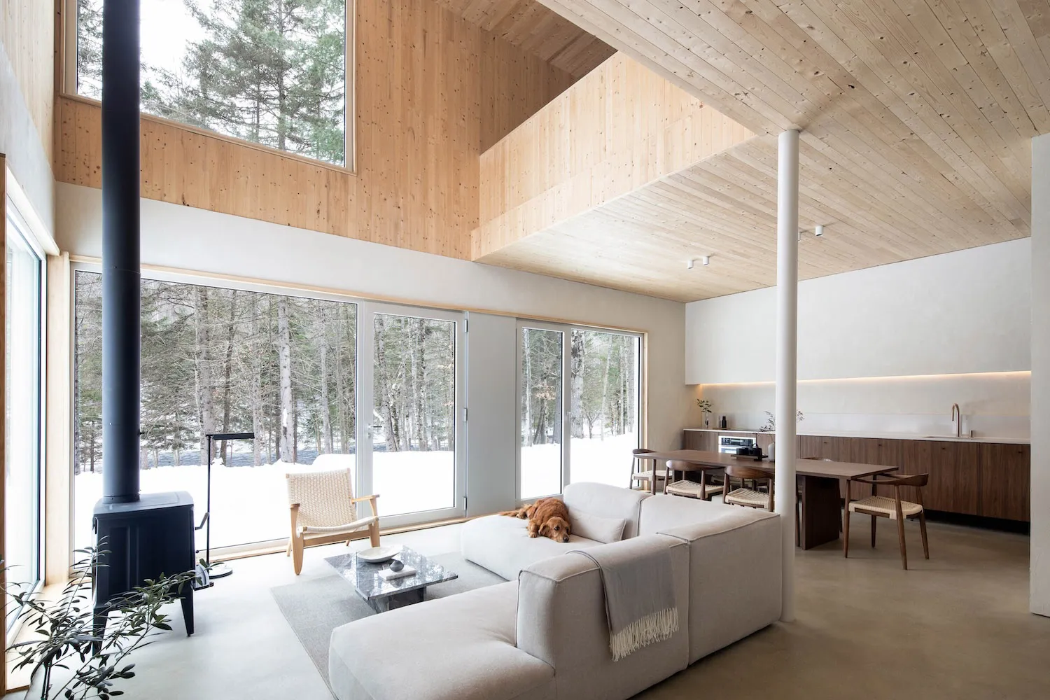 A contemporary living room with minimalist design featuring wood elements and a fireplace.