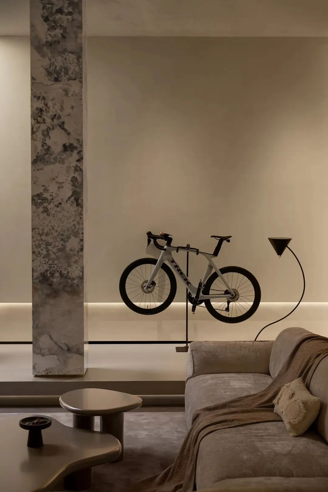 A modern minimalist living space featuring a sleek white bicycle and a contemporary floor lamp with a metallic cone shade, al