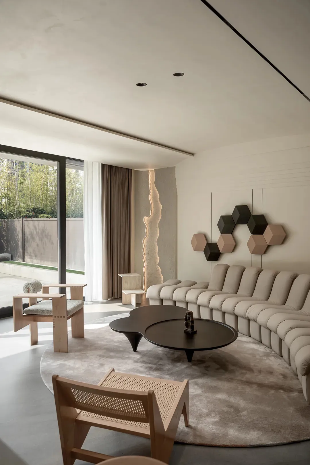 Modern interior design featuring a living room with neutral-toned, textured furniture and a distinct wall art piece.