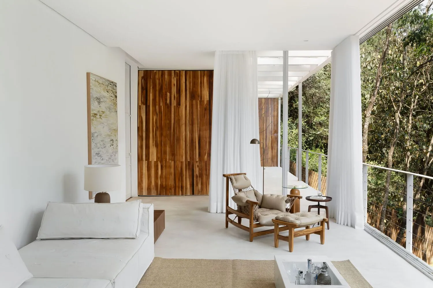 A minimalist white living space featuring wood elements and a spacious layout.
