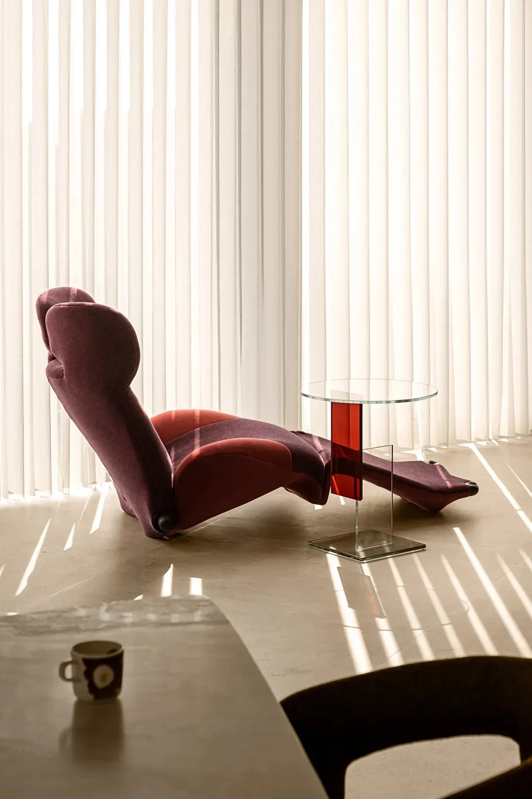Modern living room with a comfortable lounge chair and glass side table.
