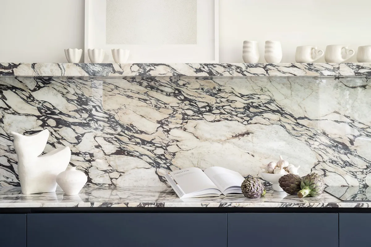 A modern minimalist kitchen features a luxury marble countertop.