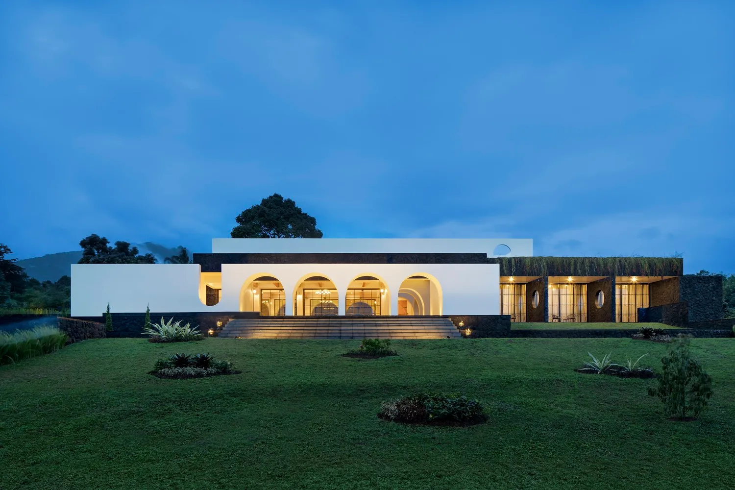 A modern residential house featuring stone, glass, and cement materials.