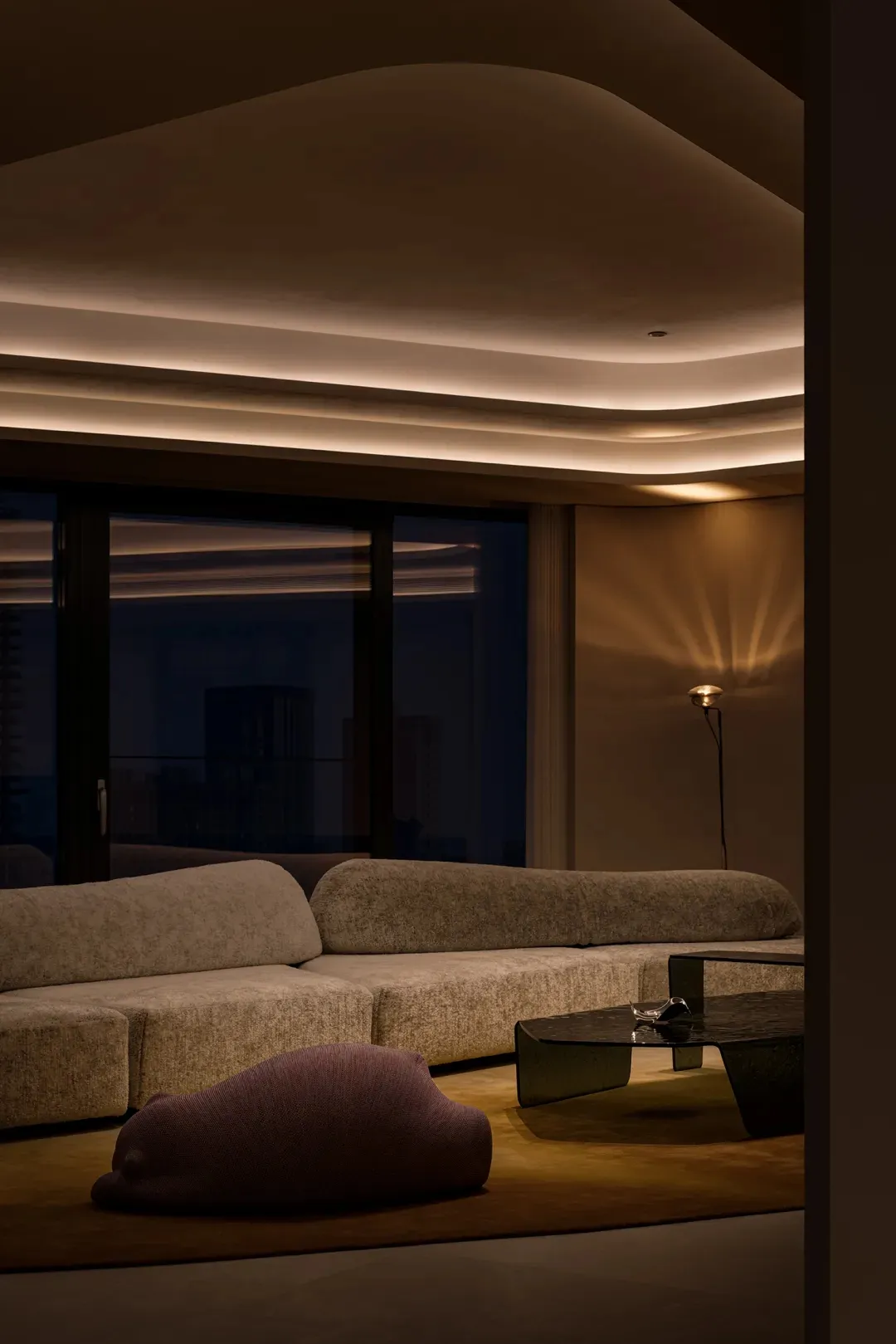 A minimalist residential interior with modern furniture and textured fabric on sofas and cushions.