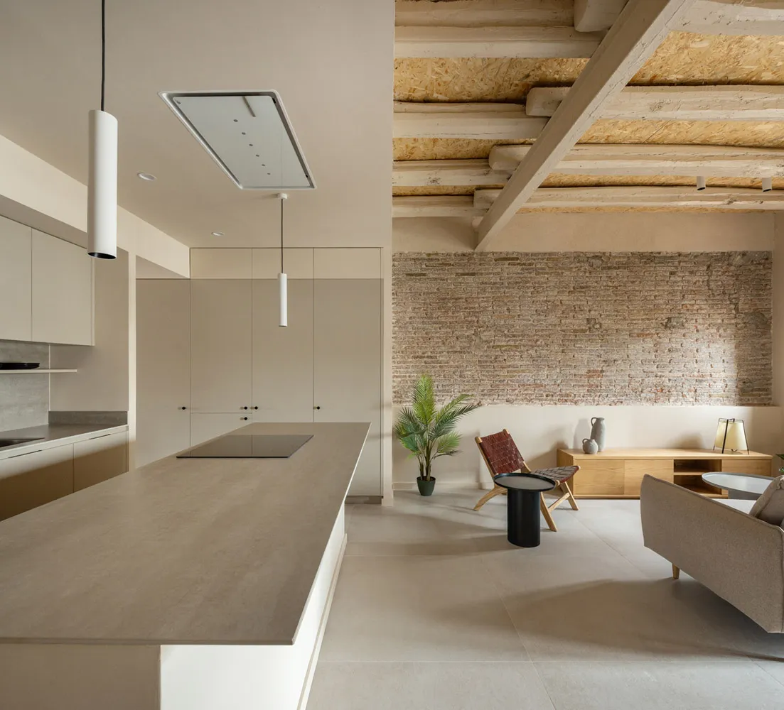 A modern kitchen with minimalist design features concrete countertops and walls.