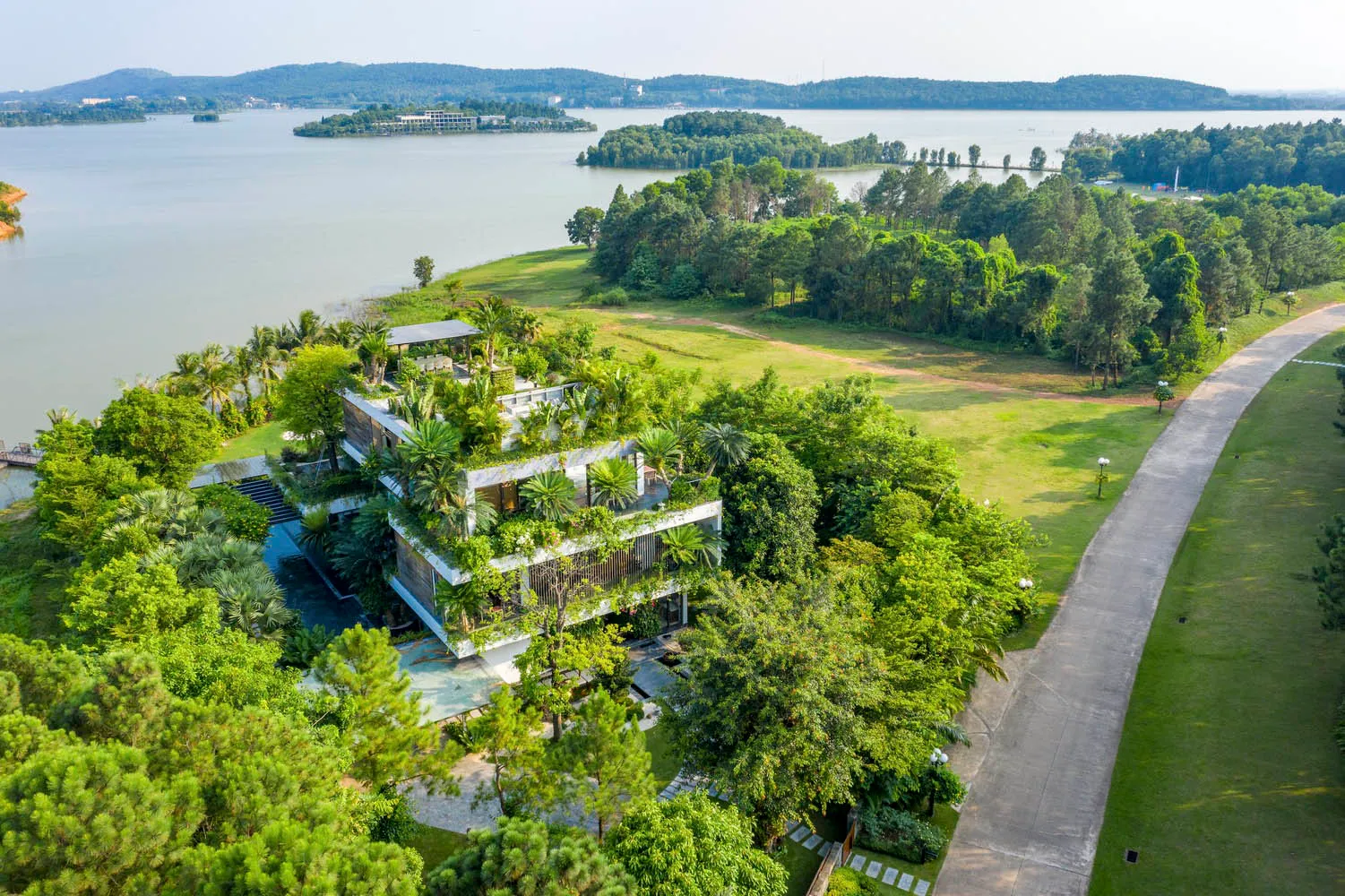 Modern residential building surrounded by lush greenery with a rooftop terrace