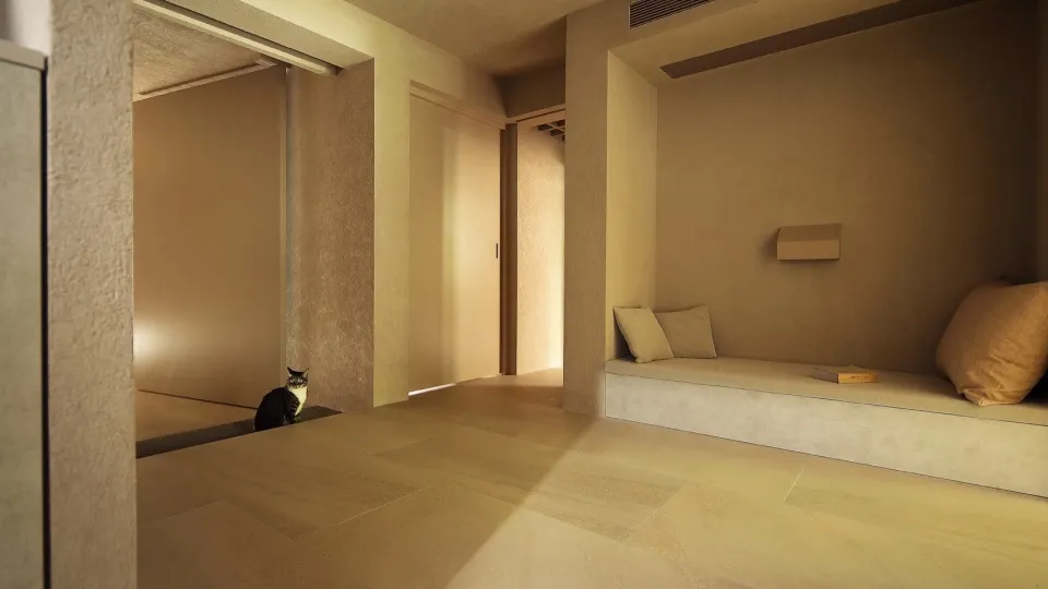 A minimalist residential living room featuring sandstone flooring and concrete walls.