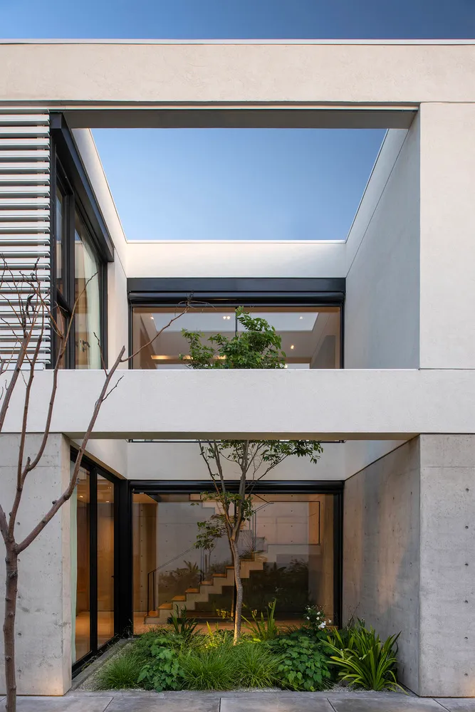 Modern architectural design featuring a glass wall and concrete structure.