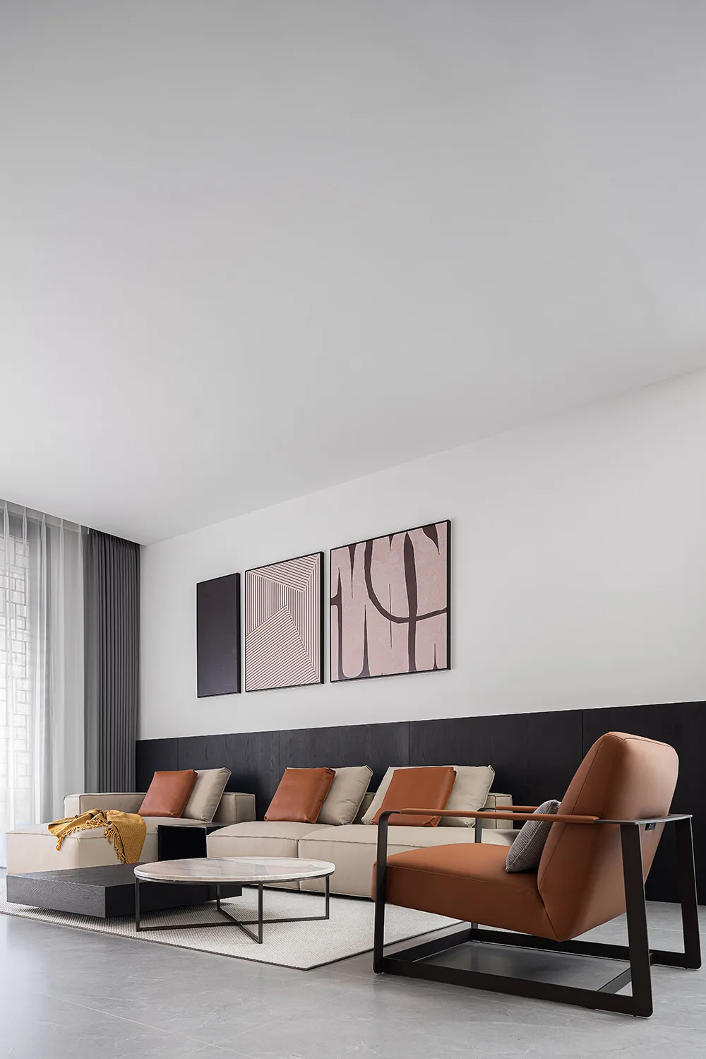 A modern living room with a neutral color palette featuring a comfortable sectional sofa, two armchairs, and a minimalist cof