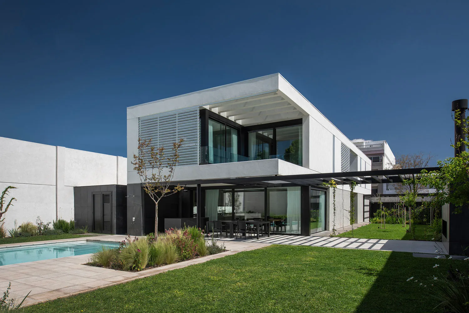 Modern residential home with concrete exterior, featuring clean lines and large windows.