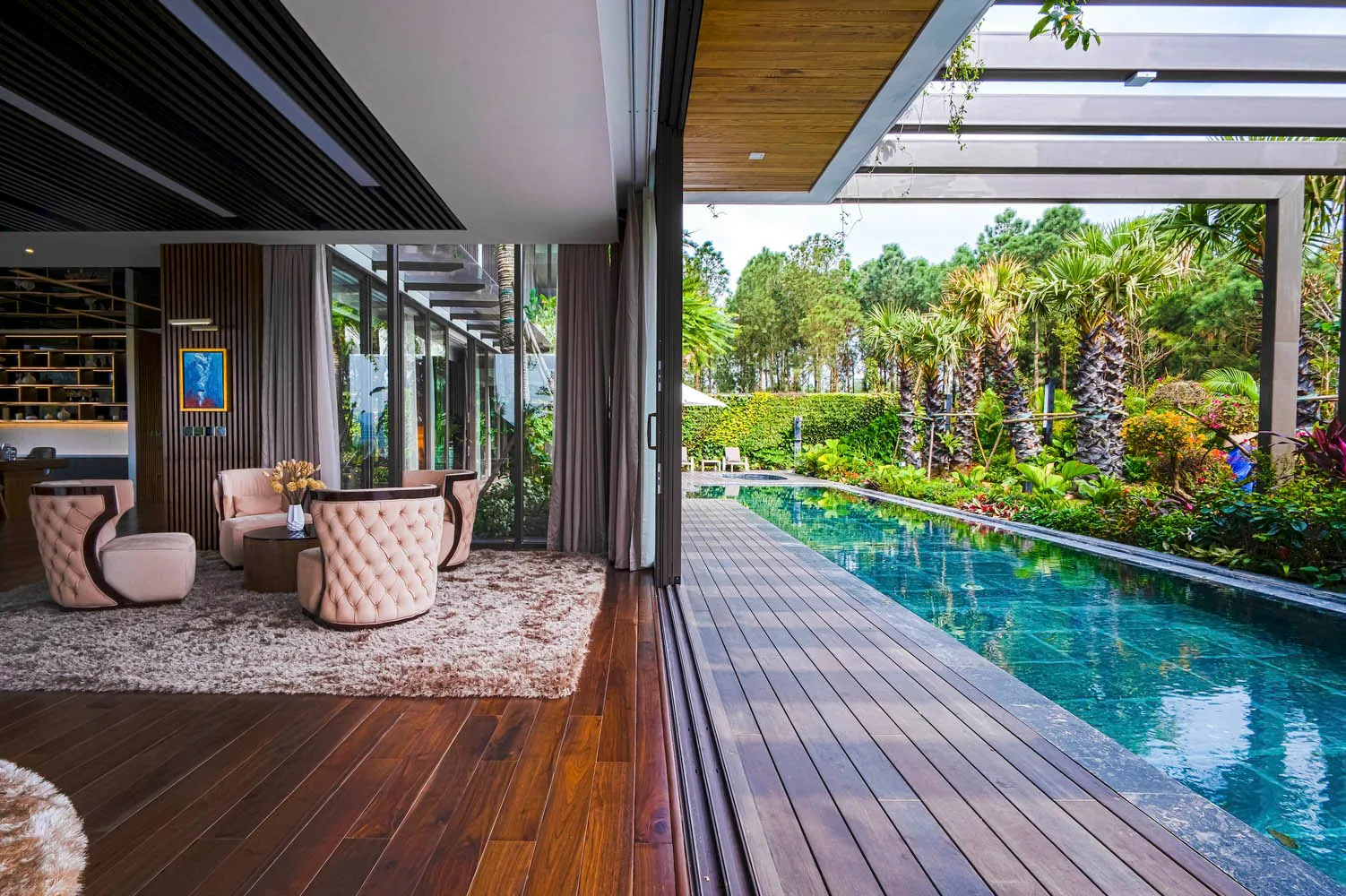 A modern residential interior featuring wood flooring and a swimming pool exterior.