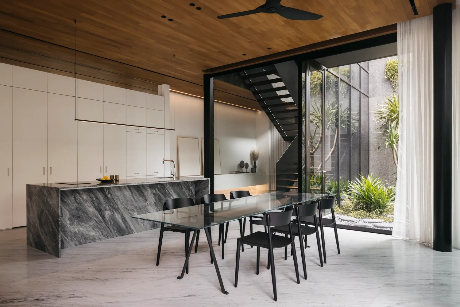 Modern residential dining room featuring marble and concrete materials.
