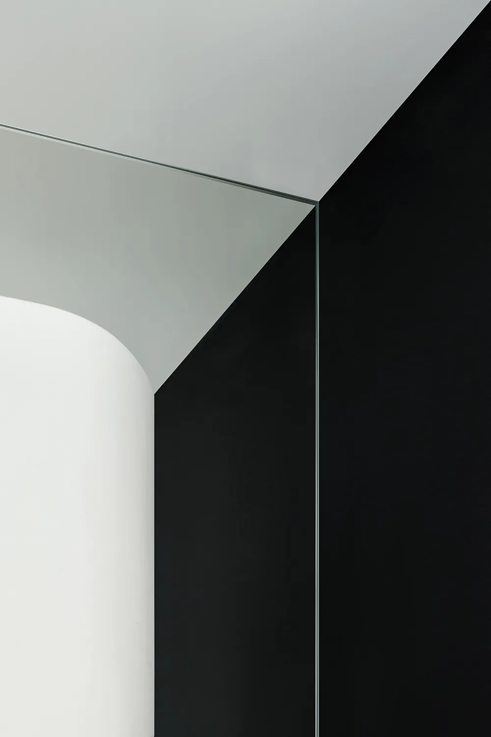 A modern black and white interior space featuring glass architectural elements.