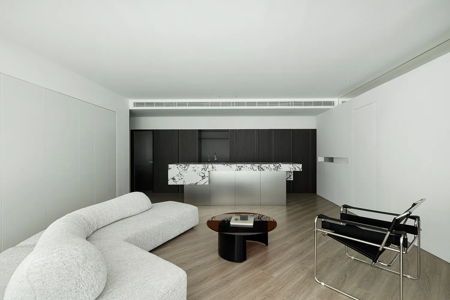 Modern living room with white furniture, concrete accents, and minimalist design