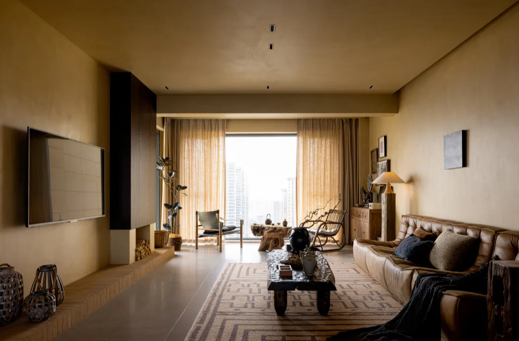 A chic living room with concrete walls, leather furniture, and industrial design elements.