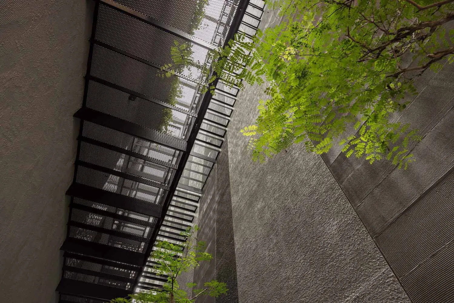 A modern interior space with a concrete wall and metal stairs.