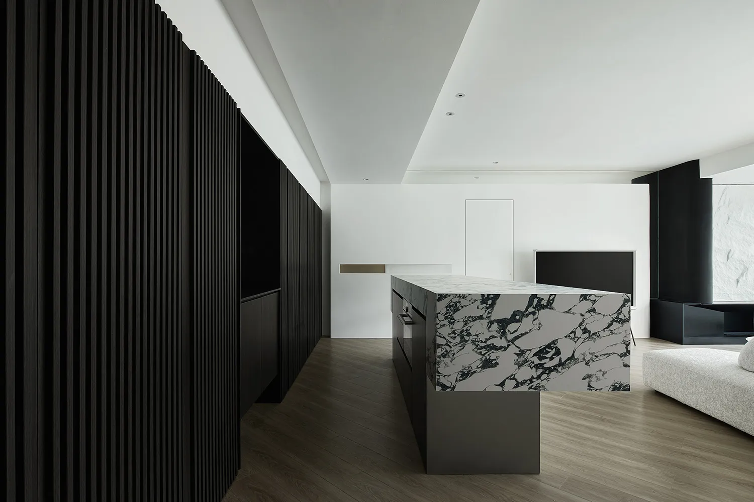 A modern kitchen featuring minimalist design with marble countertops and white cabinetry.