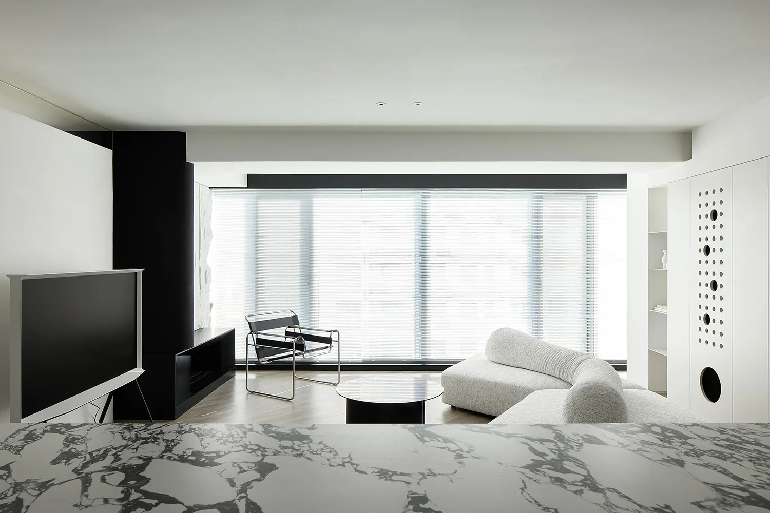 A modern living room with concrete walls and minimalistic furniture.