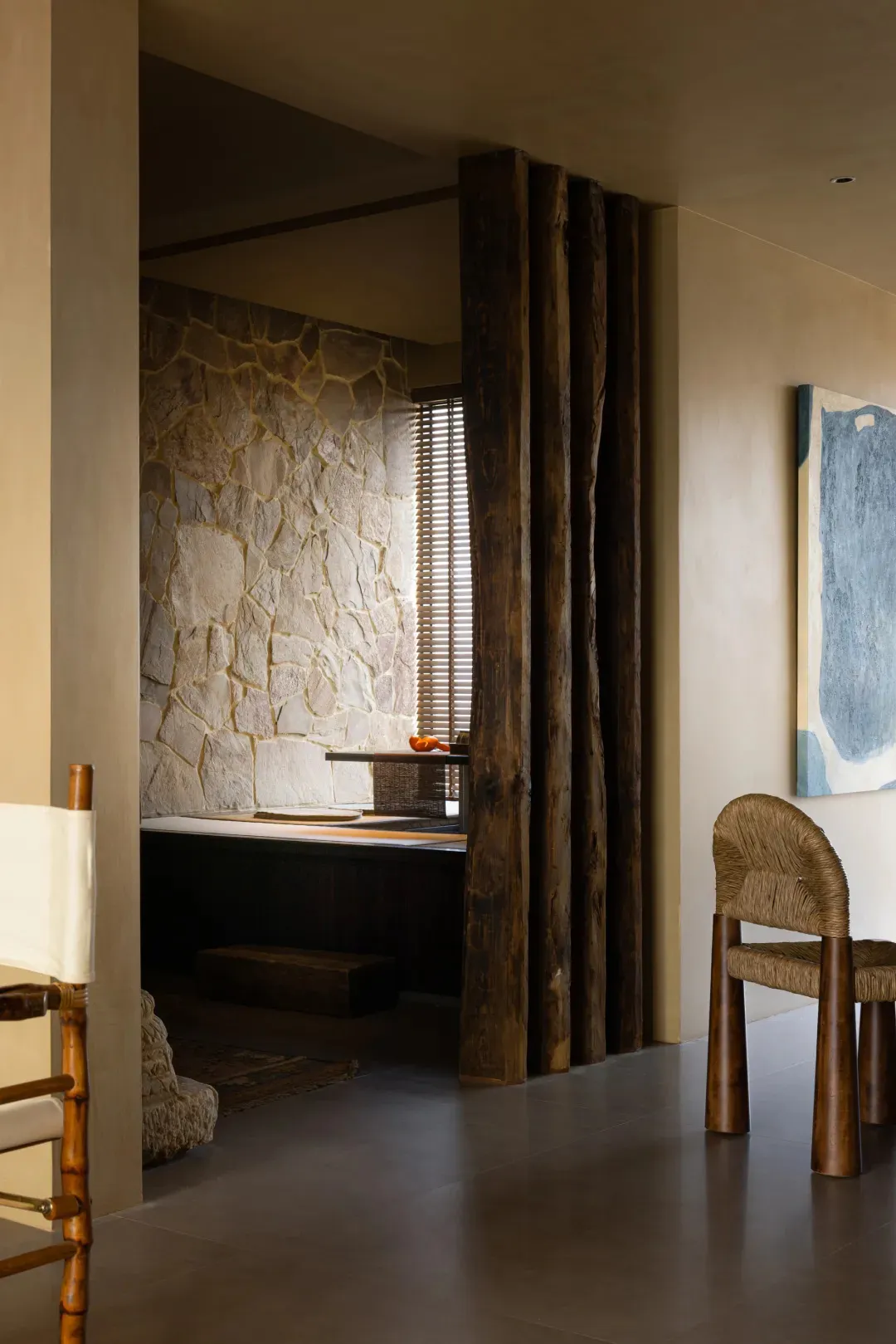 A residential interior space featuring a stone wall and concrete floor.