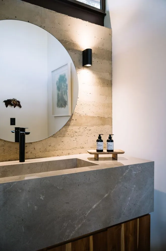 Modern bathroom with a marble sink and large round mirror