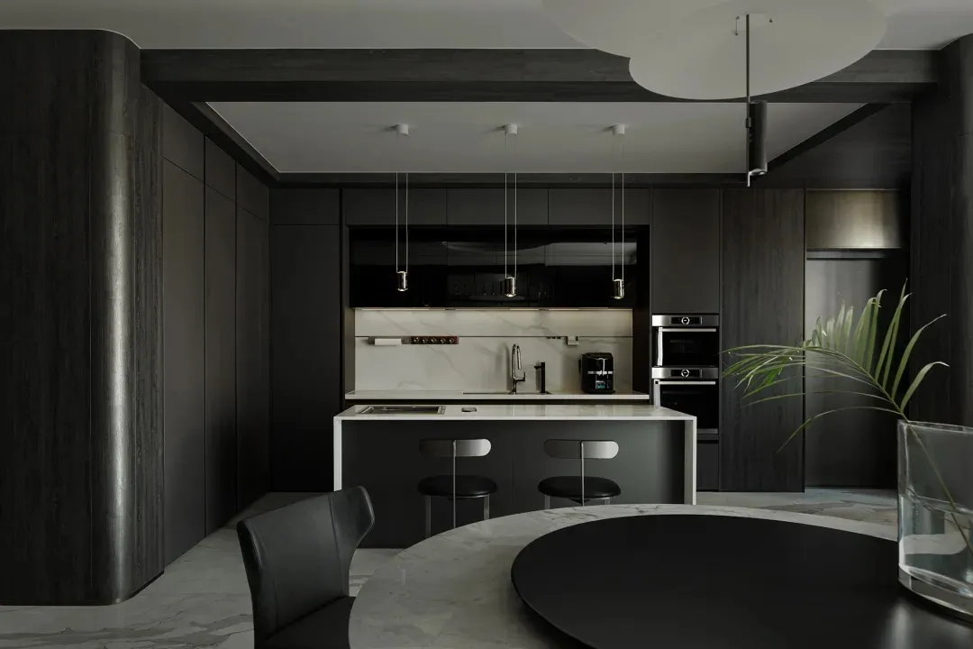 Modern kitchen featuring dark wood cabinetry and marble countertops