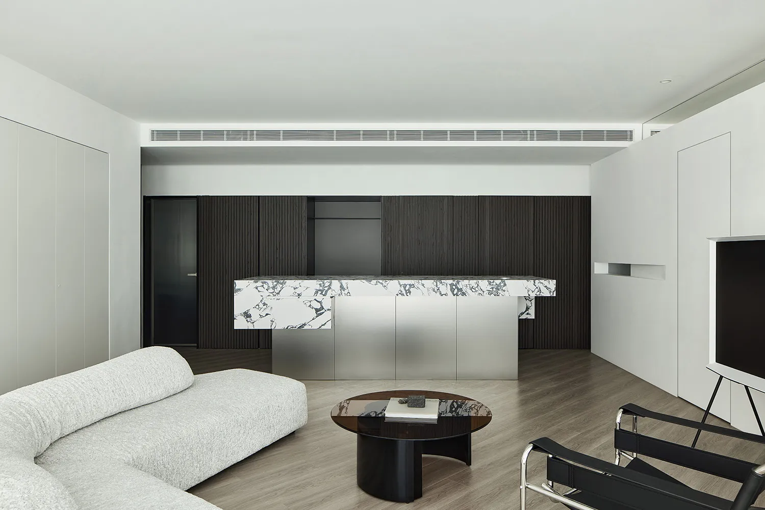 Modern living room featuring marble, stainless steel, and wood elements.