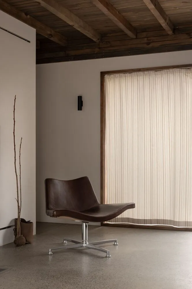 A modern interior living room with wooden furniture, minimalist decor, and a large window with vertical blinds.