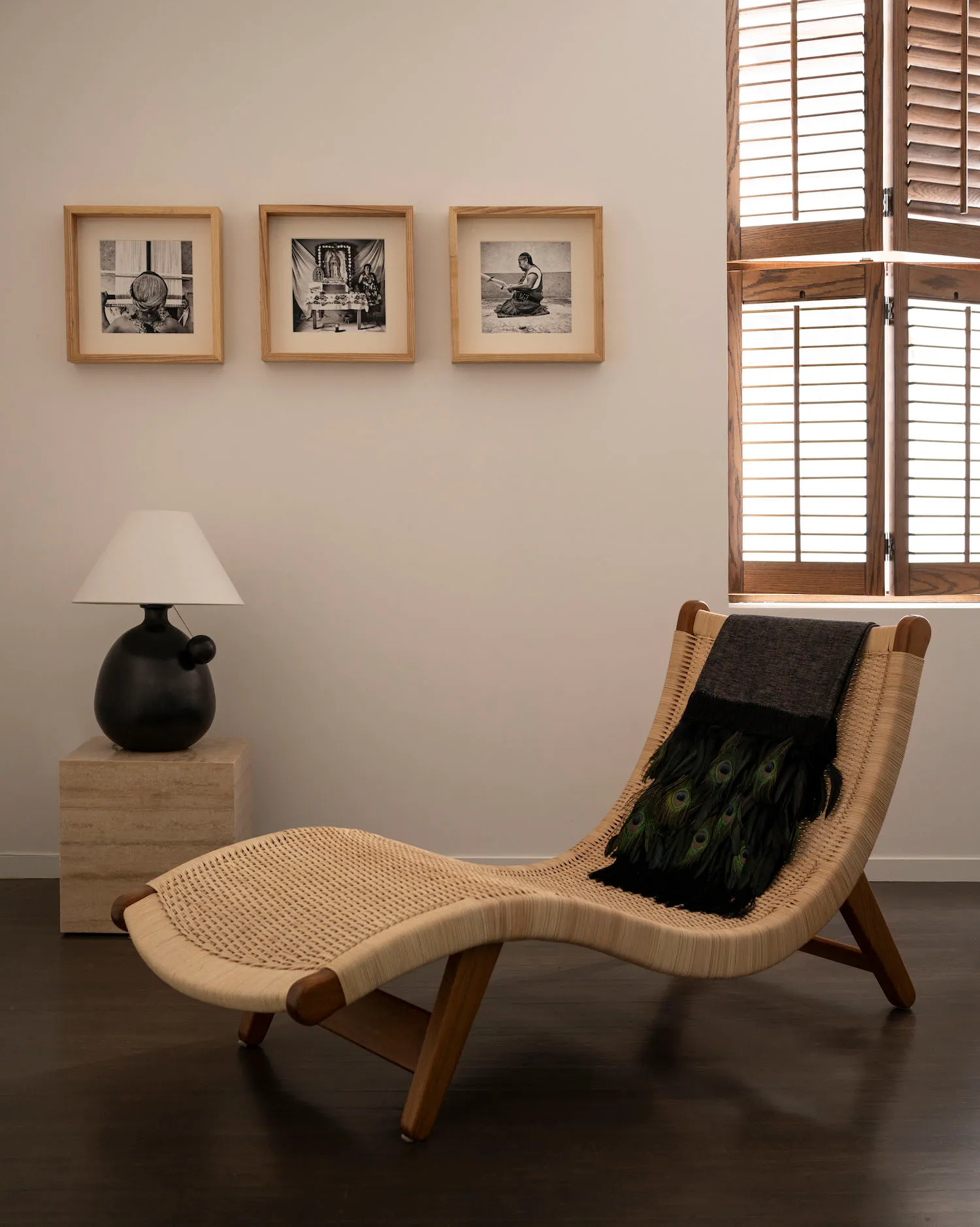 Modern living room with a wooden framed lounge chair and framed photographs on the wall.