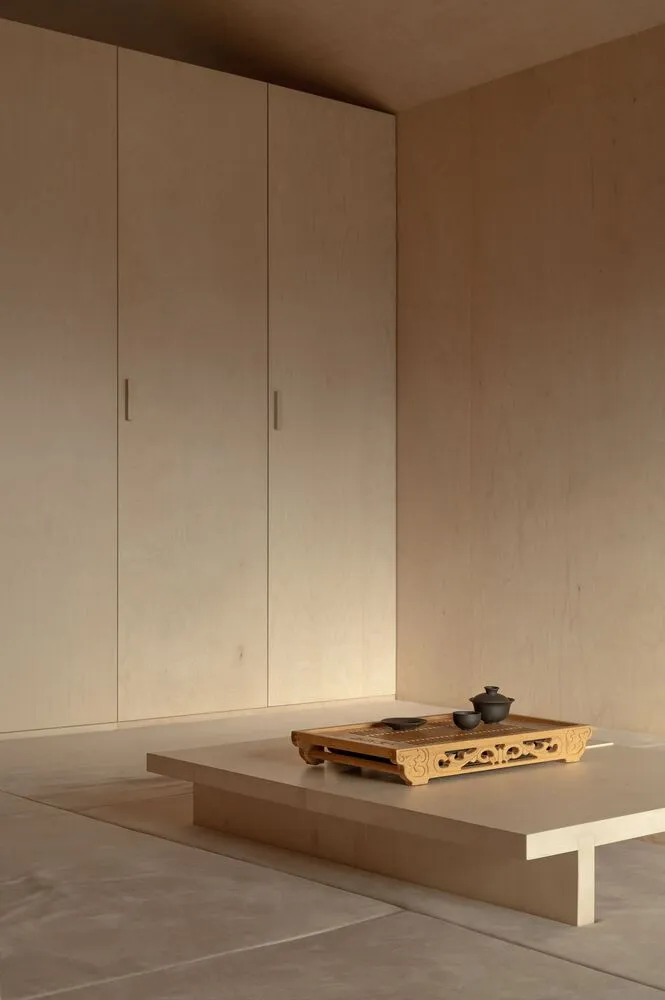 A minimalist interior design featuring wooden furniture and flooring.
