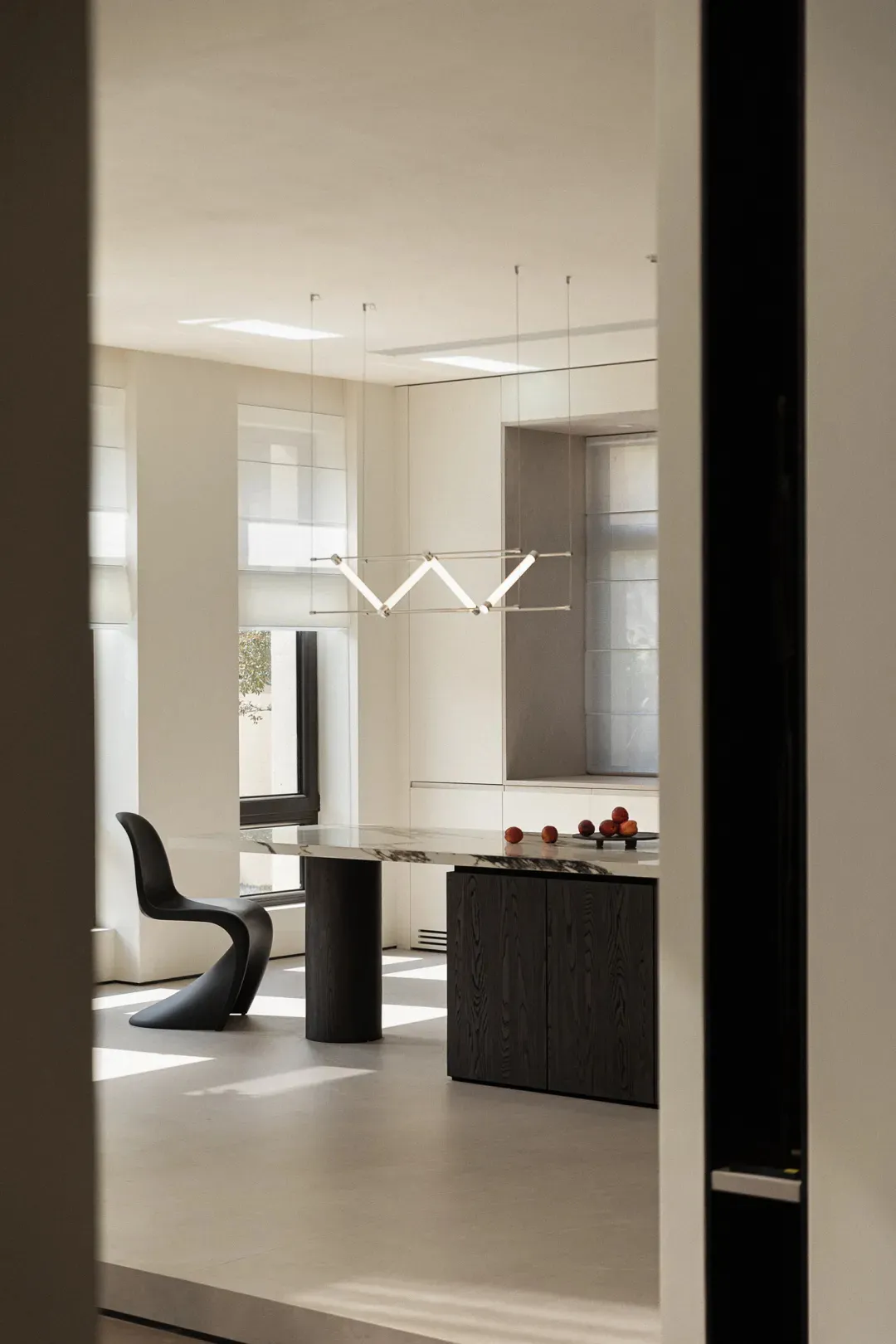 Modern kitchen interior featuring a stone countertop with fruits and minimalist design elements.