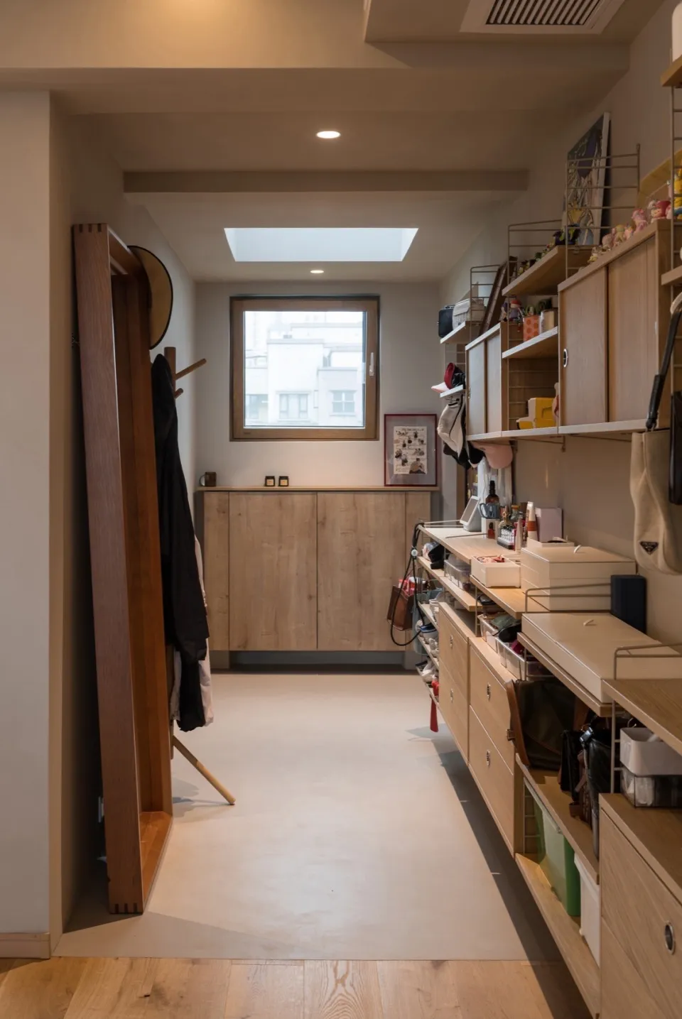 簡約風格的衣櫥,配有木製層板、櫃體與掛衣桿。