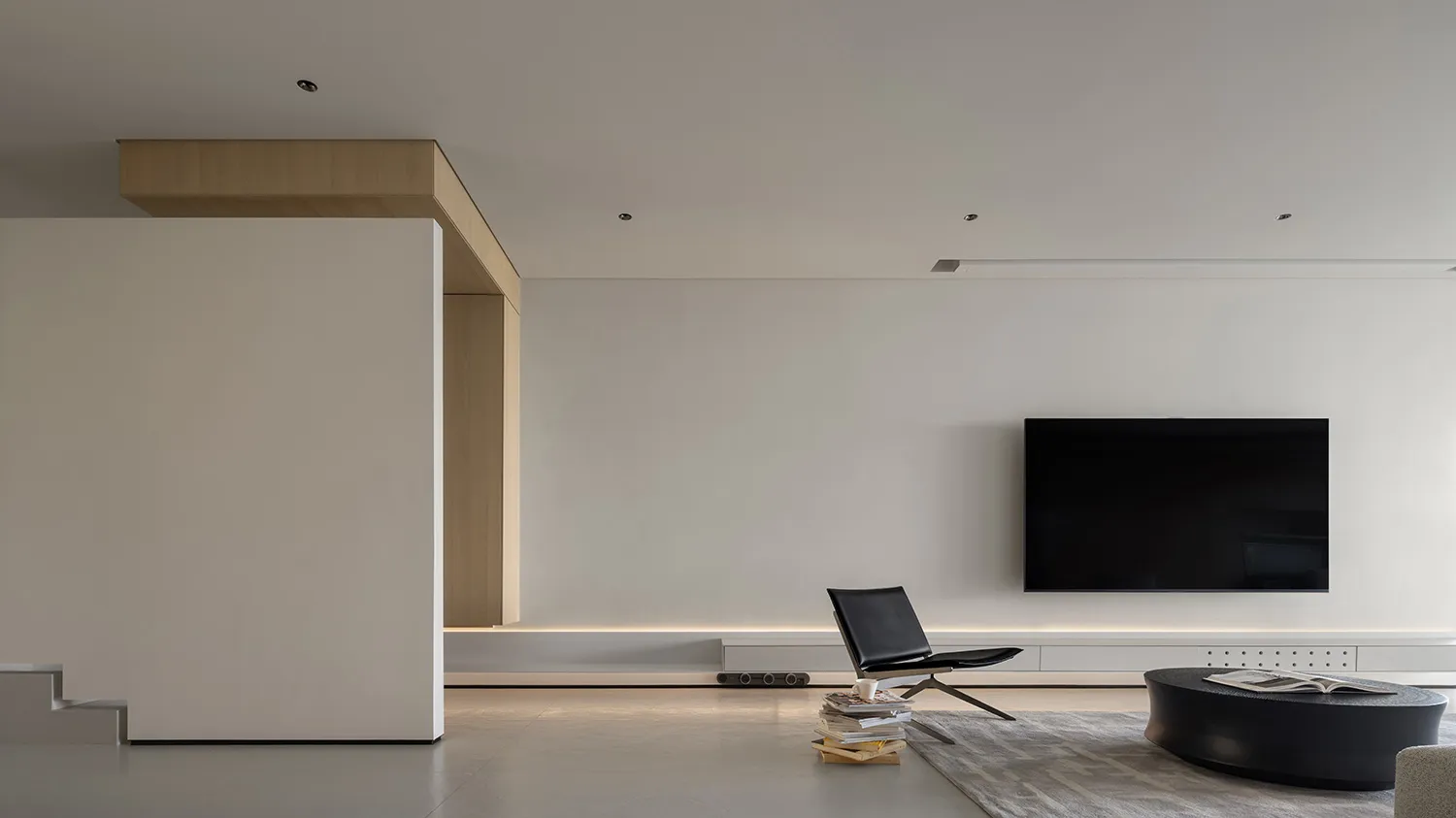 Modern minimalist living room with concrete flooring, simple furniture, and a sleek, uncluttered design.