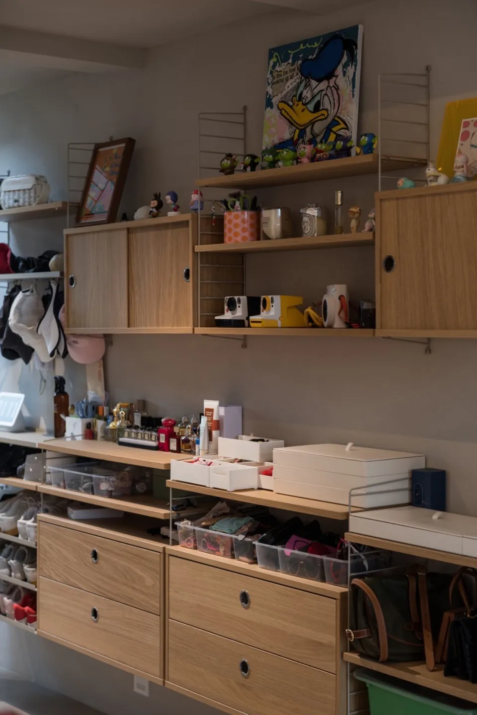A neatly organized wardrobe storage system with wooden shelves, drawers, and cabinets.