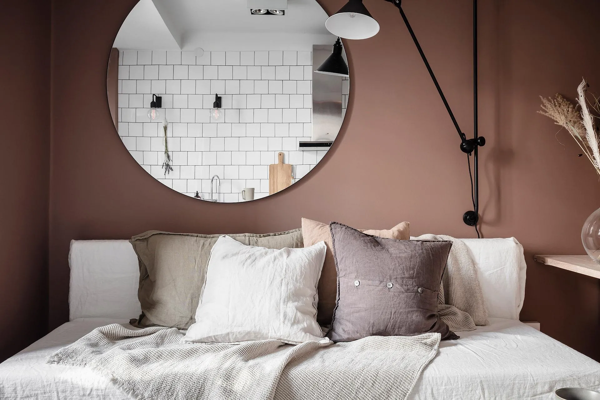 A minimalist bedroom featuring linen bedding and subtle brown walls