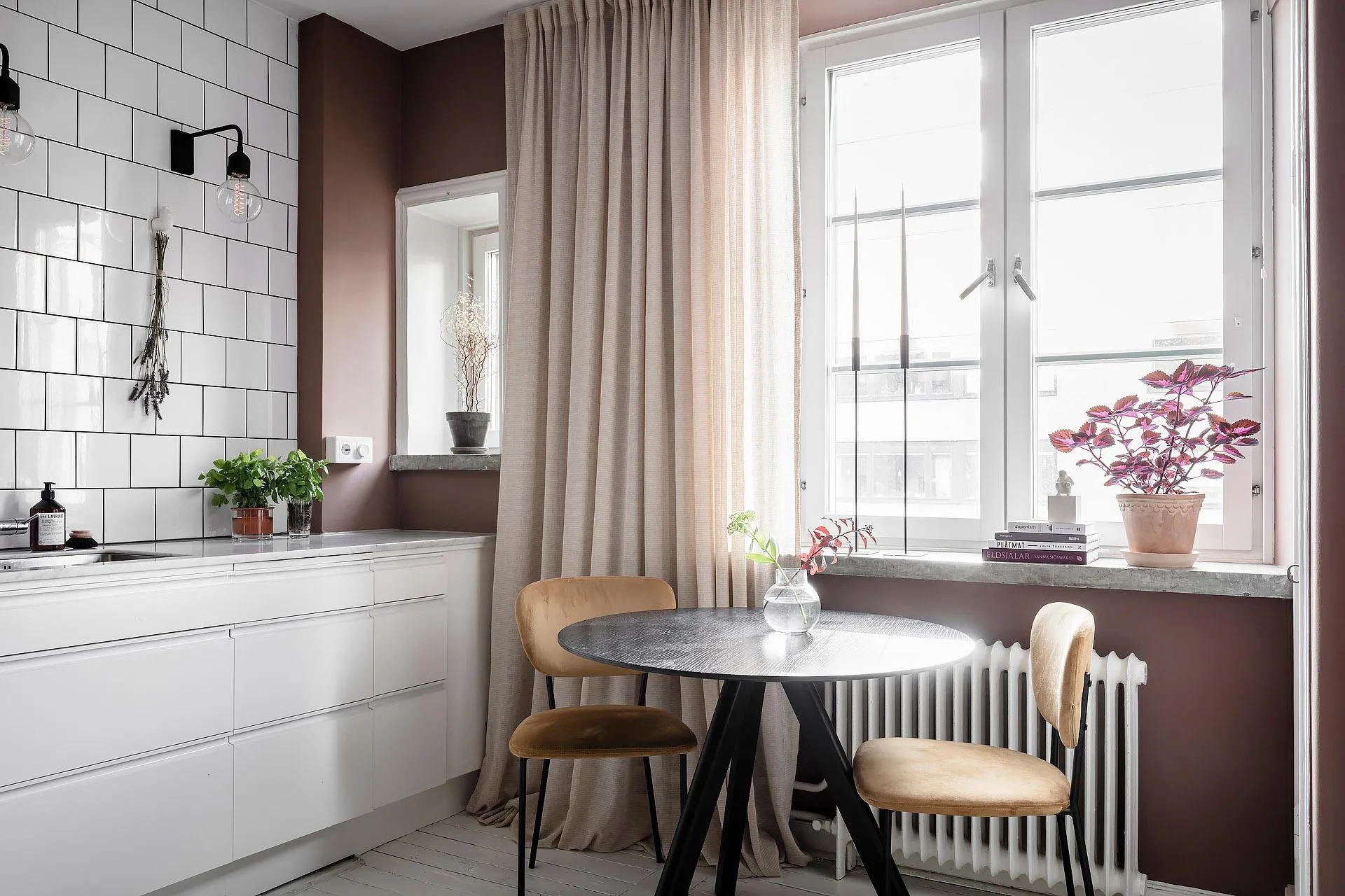 Modern, minimalist kitchen with white subway tiles and dark wooden furniture.