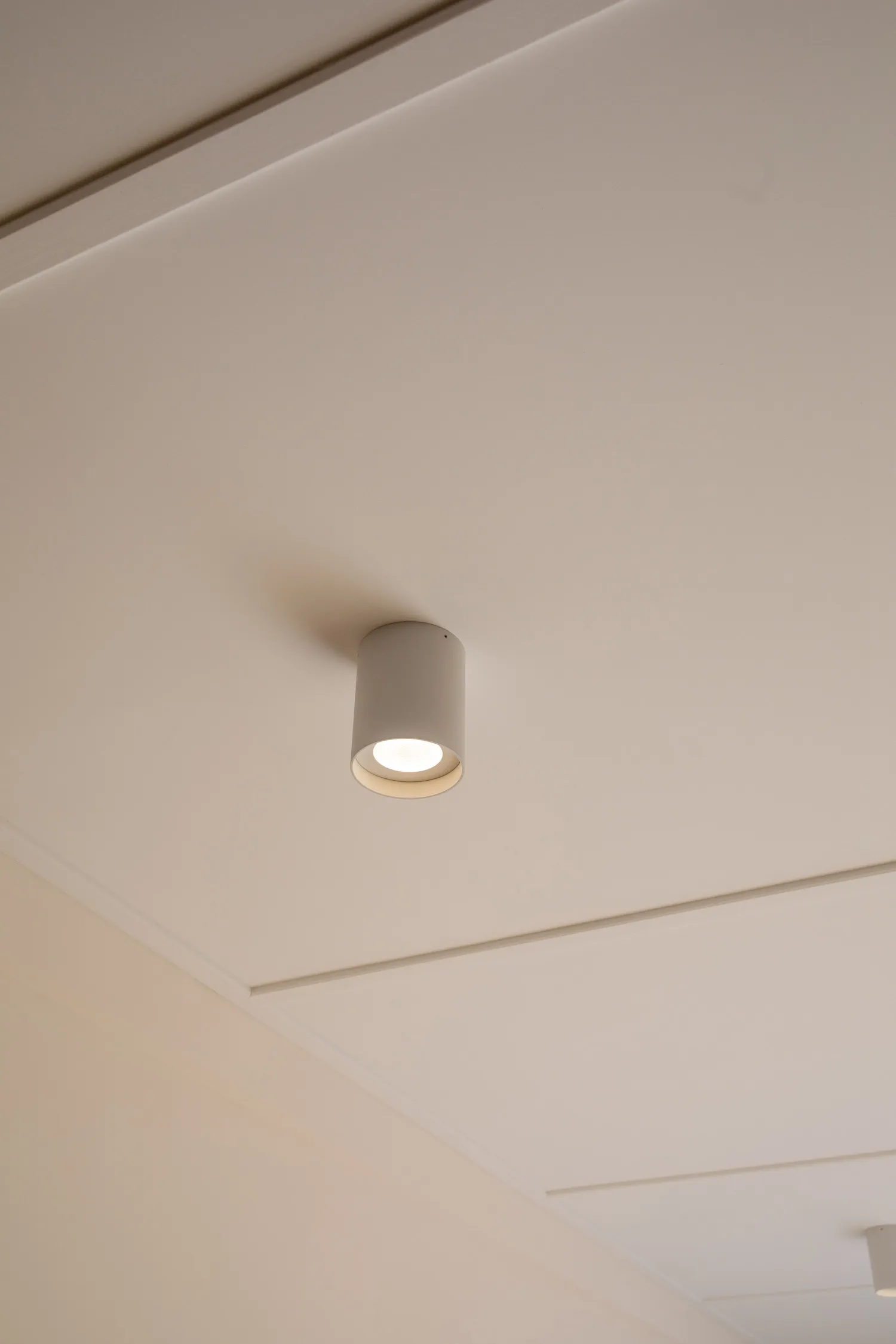 Modern minimalist ceiling light fixture on a white ceiling.