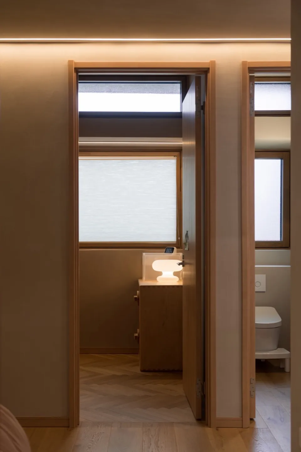 Minimalist interior design featuring a doorway with modern lighting and wooden elements.