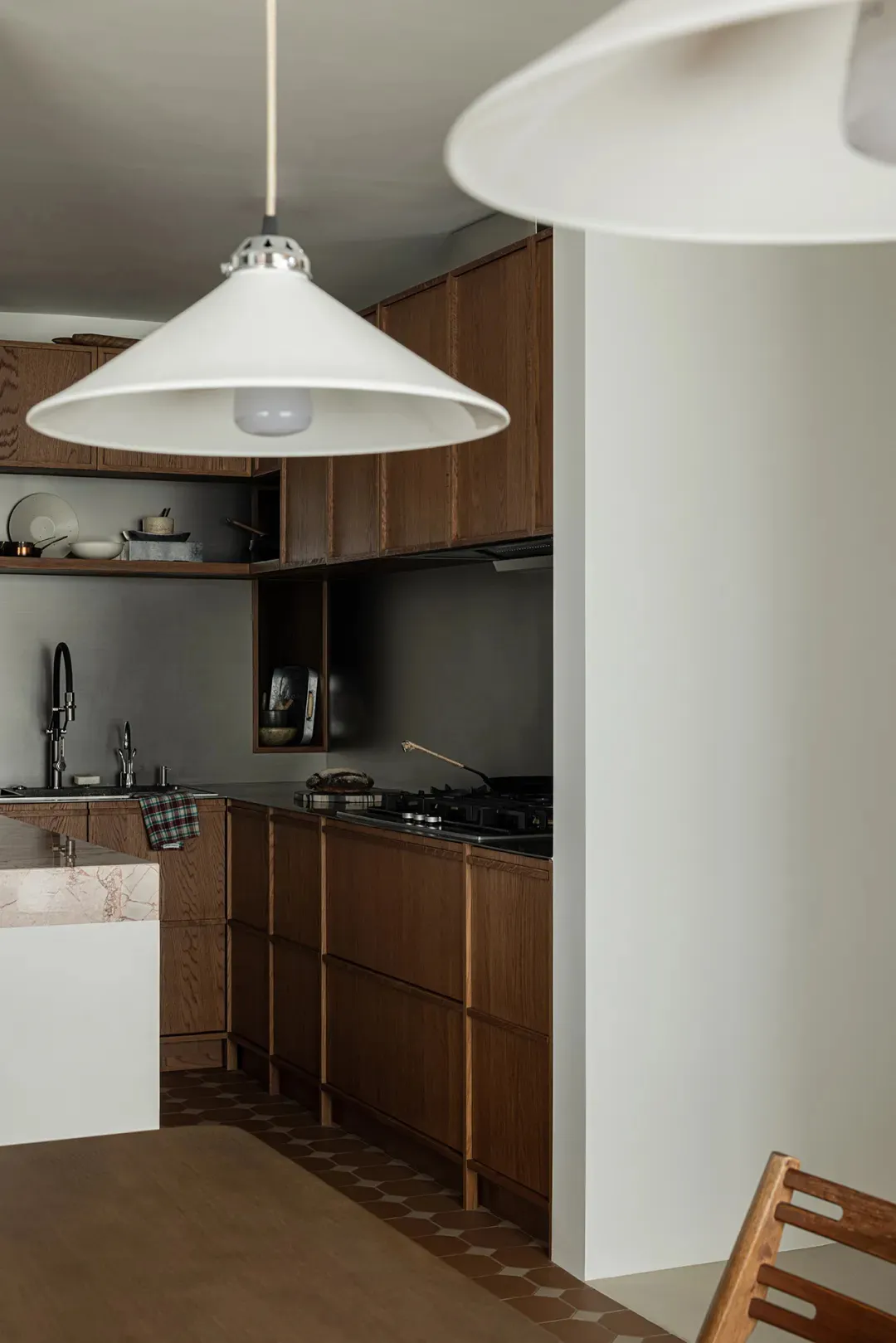 Modern minimalist kitchen featuring natural wood cabinets and marble countertops.