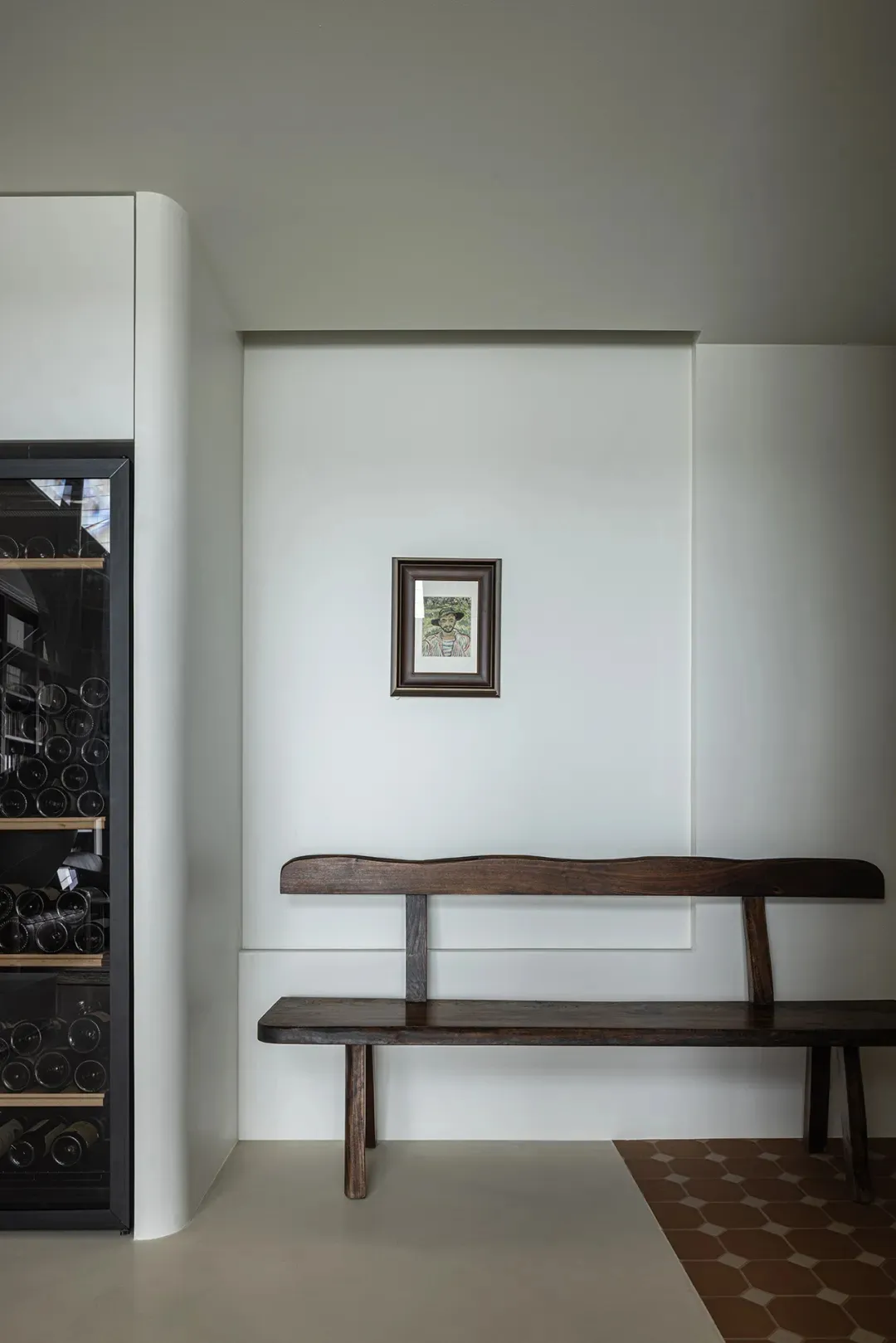 Modern minimalist interior with wooden bench and glass cabinet.