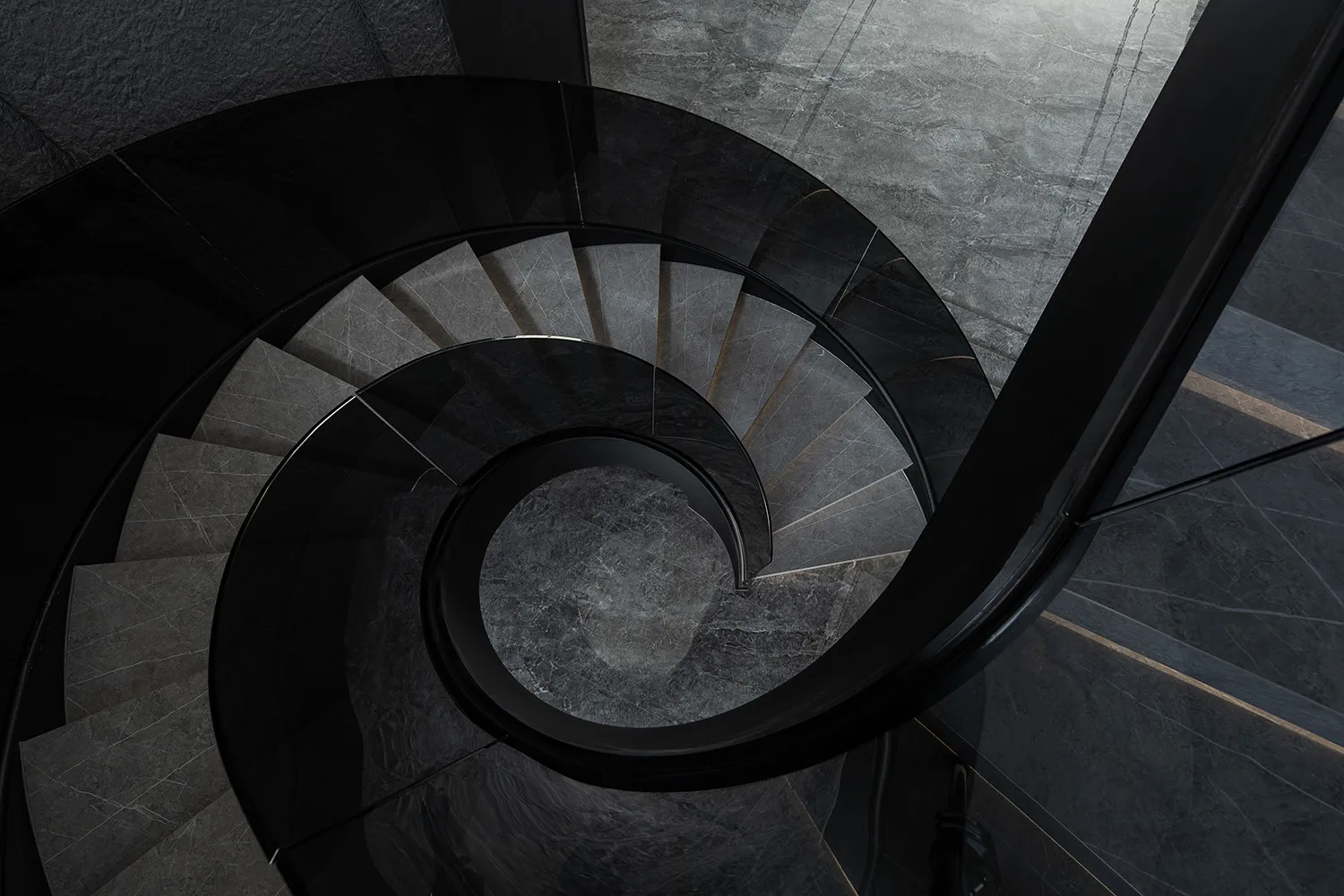 A modern spiral staircase featuring glass railings and steps, set against a dark background.